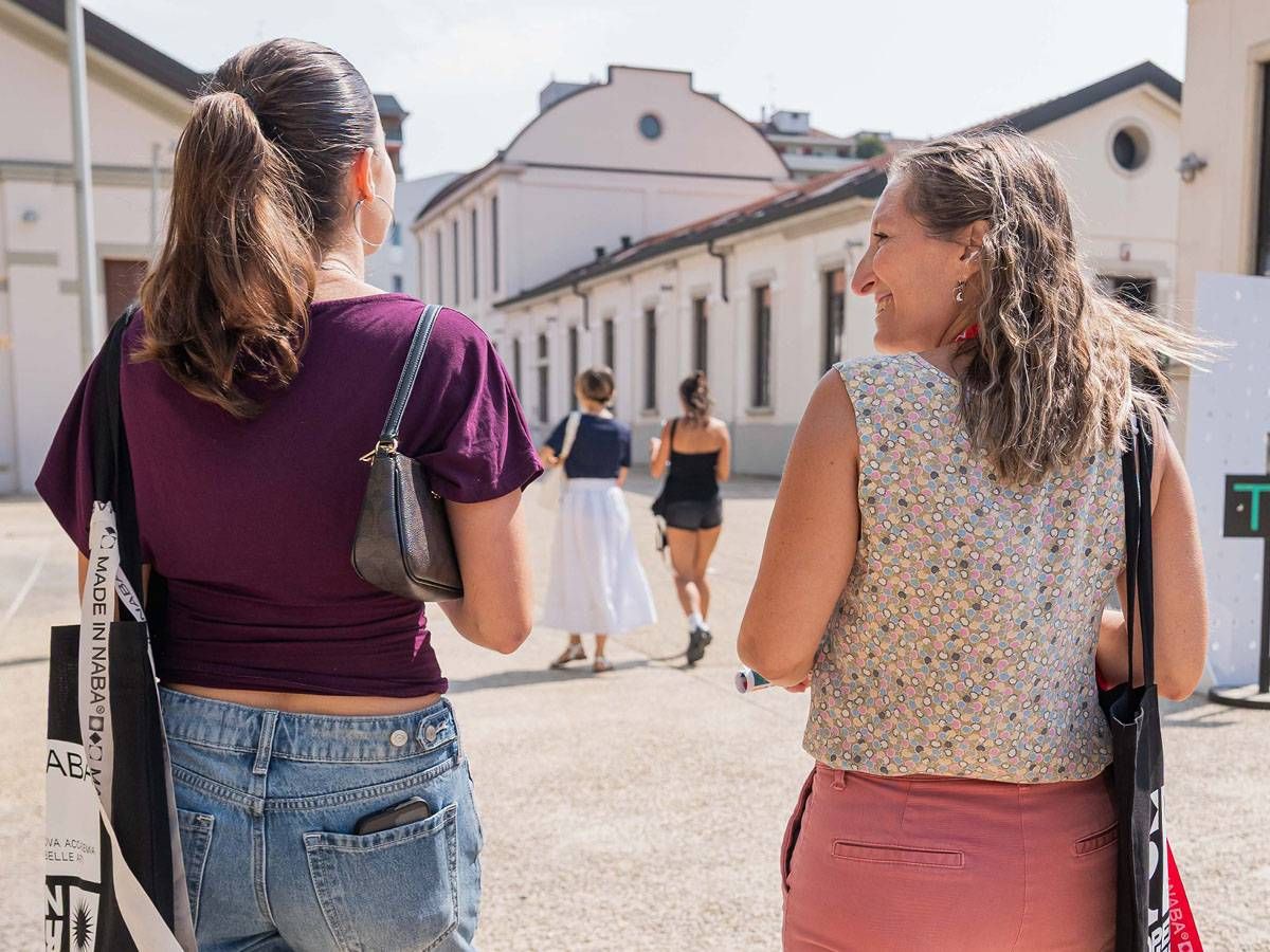 Docente NABA dialoga con un piccolo gruppo durante la visita al campus.
